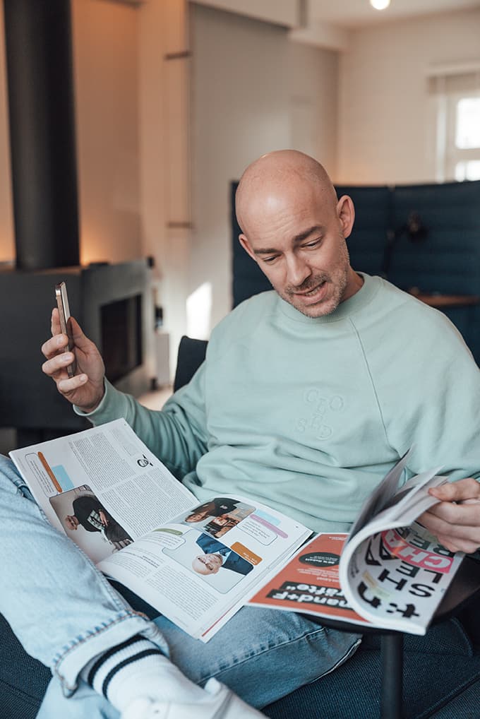 Christoph Magnussen liest ein t3n Magazin auf einem Sofa.